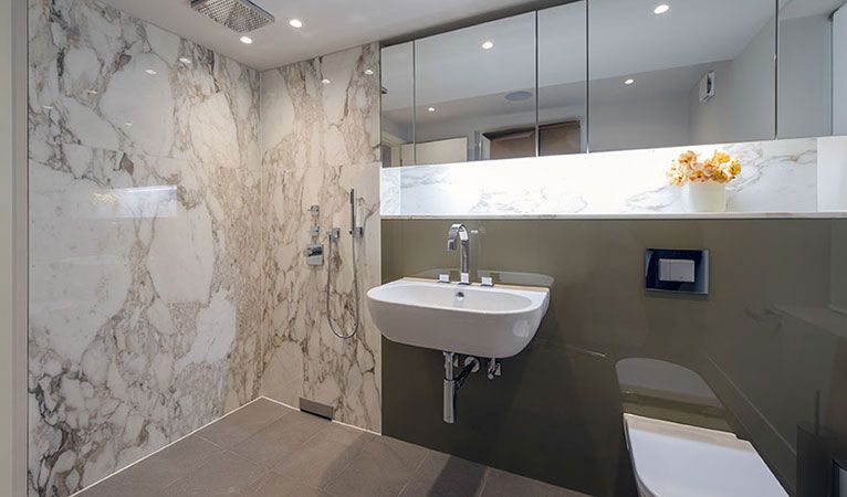 Master En-suite bathroom with back painted glass, marble shower enclosure & wall hung Gerberit WC & basin in Kensington SW7